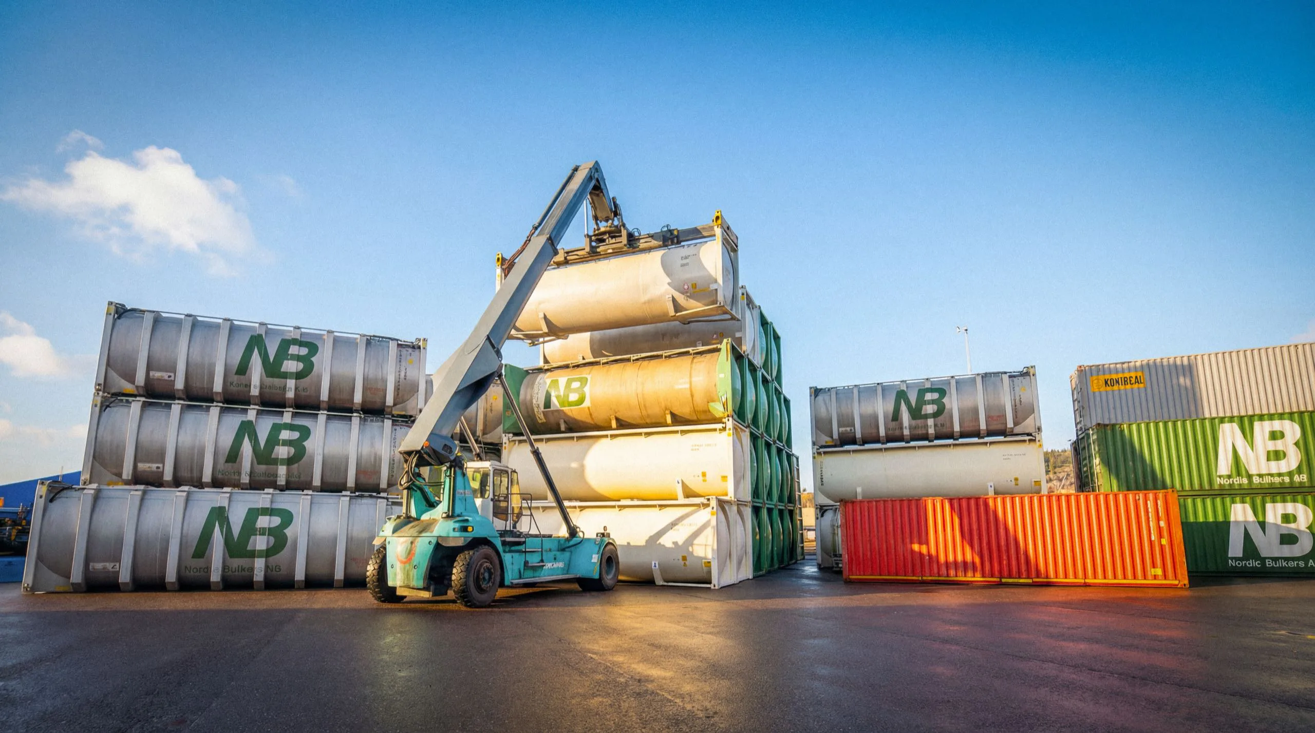 En reachstacker hanterar tankcontainrar på ett depåområde.